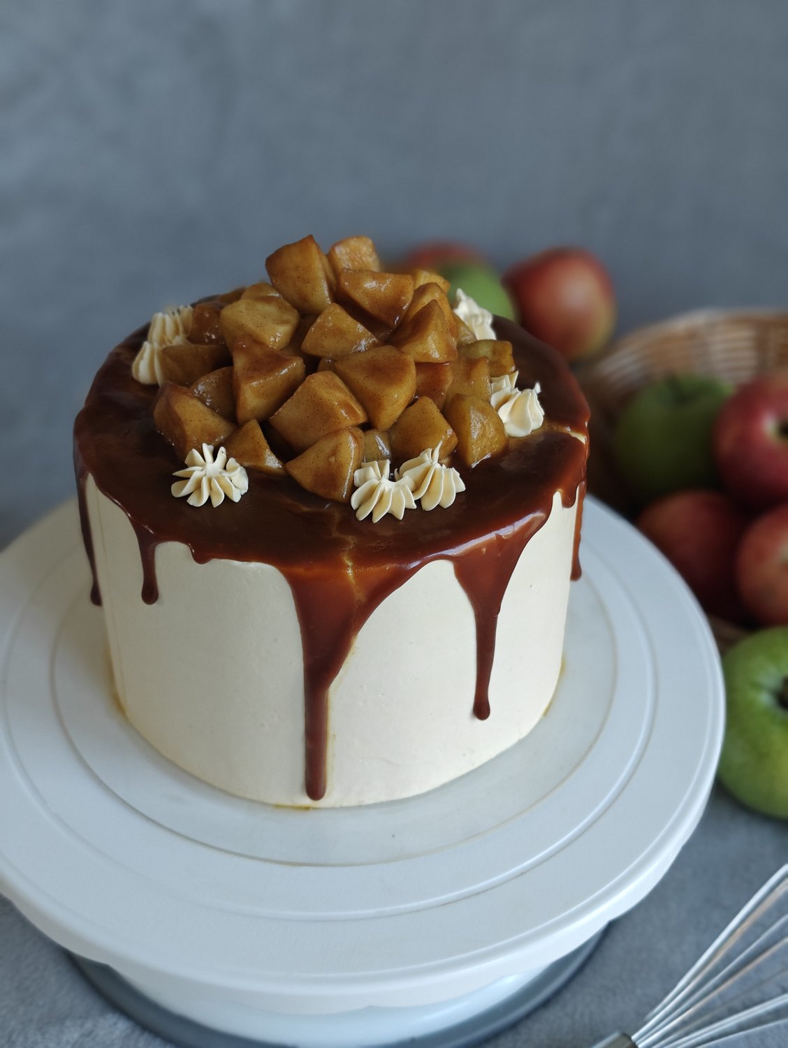 Two-tier cake with caramel drip and apple slices